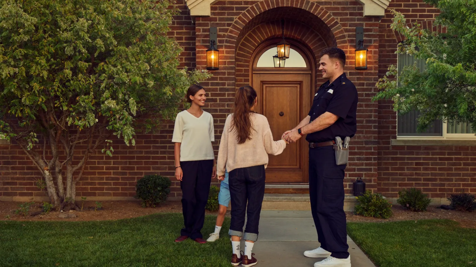 A Catawba Comfort technician greeting a family at the door of a Charlotte home
